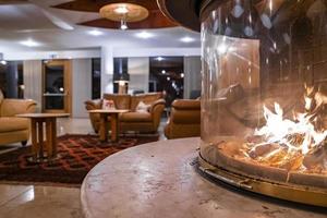 Close-up of fireplace in glass with sofa in background at luxurious hotel lobby photo