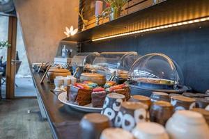 Assortment of fresh sweet cake slices in plate on counter at restaurant photo