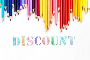 Multi-colored wooden sticks Wooden colouring pencils and Discount on white background photo