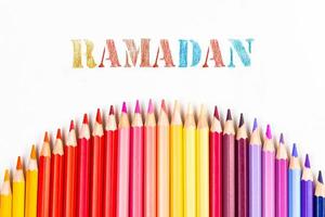 Multi-colored wooden sticks Wooden colouring pencils and ramadan on white background photo