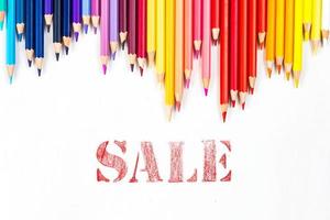 Multi-colored wooden sticks Wooden colouring pencils and sale on white background photo