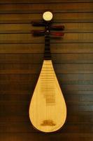 A pipa hanging on a wall. It is a four-stringed Chinese musical instrument. photo