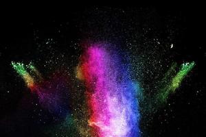 Launched multicolored powder on black background.Color powder explosion.Colorful dust splashing. photo