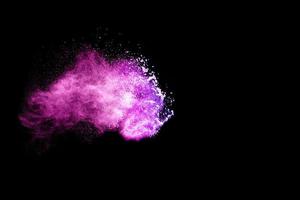 Purple color powder explosion cloud on black background.Closeup of purple dust particle splash  on  background. photo