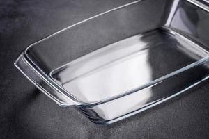 A rectangular glass empty dish for baking on a dark concrete background photo