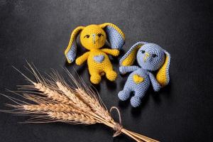 Two toy hare tied by hand in the colors of the flag of Ukraine. Save the lives of the children of Ukraine photo