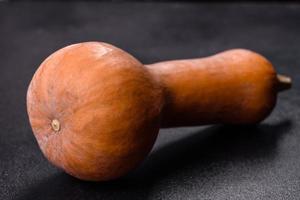 A beautiful fresh orange pumpkin against a dark concrete background photo