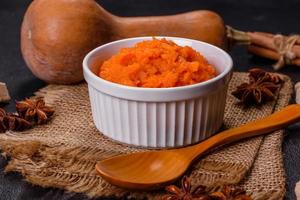 Pumpkin carrot baby puree in bowl on a dark background photo