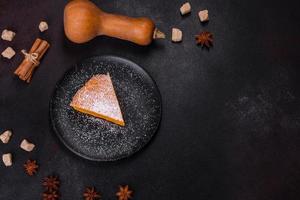 Pumpkin pie, tart made for Thanksgiving day with whipped cream on a black plate photo