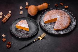 Pumpkin pie, tart made for Thanksgiving day with whipped cream on a black plate photo