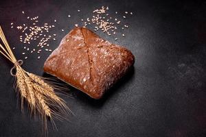 Beautiful tasty, square-shaped brown bread on a dark concrete background photo