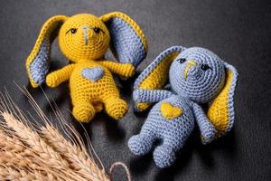 Two toy hare tied by hand in the colors of the flag of Ukraine. Save the lives of the children of Ukraine photo