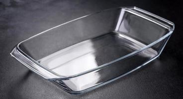 A rectangular glass empty dish for baking on a dark concrete background photo