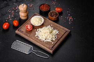 Image of a bar and grated mozzarella cheese on a dark background photo