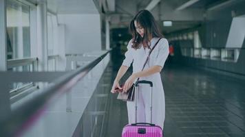 eine reisende frau trägt eine schutzmaske auf dem internationalen flughafen, reise unter einer covid-19-pandemie, sicherheitsreisen, soziales distanzierungsprotokoll, neues normales reisekonzept. video