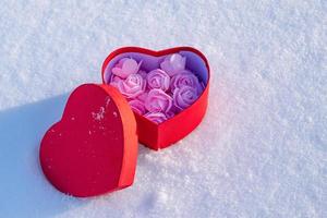 caja de regalo en forma de corazón con un regalo para una niña en el día de san valentín o el 8 de marzo foto