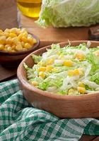 Chinese cabbage salad with sweet corn in a wooden bowl photo
