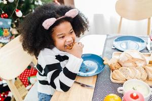 Happy family are having dinner at home. Celebration holiday and togetherness near Christmas tree. African American family. photo