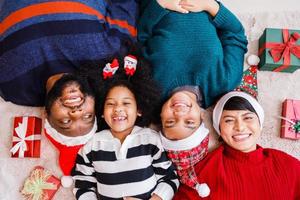 African American family in Christmas theme. Happy African American family of four bonding lying on the floor together. photo