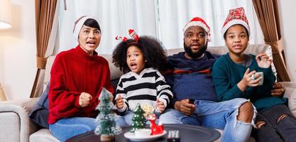 African American family in Christmas theme. Happy family has fun sitting together on the sofa at home. photo