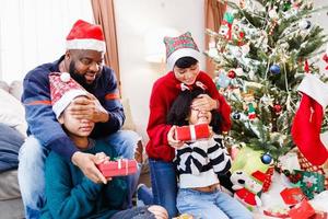 African American family surprising with a gift on Christmas day. Merry Christmas. photo