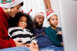 African American family have fun during video call on laptop and sitting together on the sofa photo