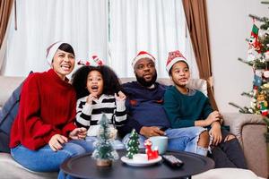 African American family in Christmas theme. Happy family has fun sitting together on the sofa at home. photo
