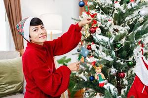 la familia afroamericana ayuda a decorar el árbol de navidad en casa. Feliz Navidad. foto