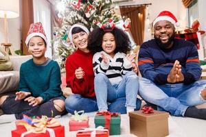 African American family in Christmas theme. Happy African American family of four bonding sitting on the floor together photo