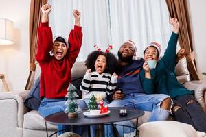 African American family in Christmas theme. Happy family has fun sitting together on the sofa at home. photo