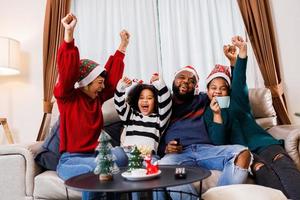 African American family in Christmas theme. Happy family has fun sitting together on the sofa at home. photo