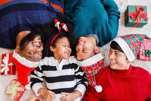 African American family in Christmas theme. Happy African American family of four bonding lying on the floor together. photo