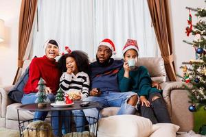 African American family in Christmas theme. Happy family has fun sitting together on the sofa at home. photo