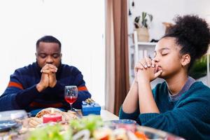 familias juntas para orar antes de las comidas en casa. foto