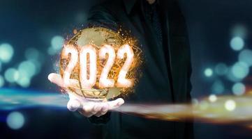 Businessman holding virtual 2022 number photo