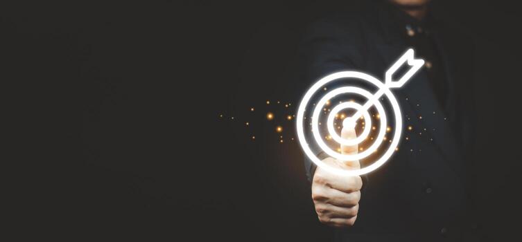 Businessman holding virtual dartboard and arrow with copy space for setup business objective target concept. photo