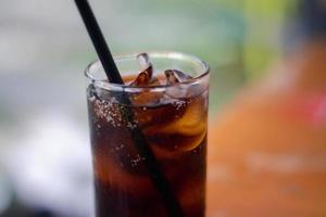 Close-up shot of a glass of cold cola. Soft drink, soft drink in a glass with ice . photo