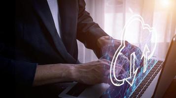 Businessman using laptop to store data with cloud computing technology photo