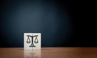 law flat icon on cube block on wooden table over dark background . photo