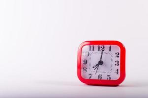 A red clock on a white background photo