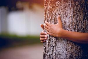 la imagen ha abrazado los árboles de los jóvenes que aman la naturaleza. concepto de cuidado natural foto