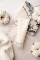 Top view Mockup facial skincare product white tube with blank label on marble background photo