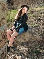 Stylish hipster woman traveler sitting on the stone by the old bridge viaduct. Traveling, Europe, fashion, style concept photo