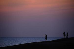 people sunrise at the sea photo