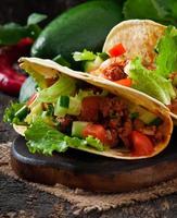 Mexican tacos with meat, vegetables and cheese photo