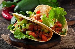 Mexican tacos with meat, vegetables and cheese photo