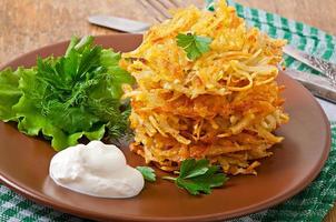 Fragrant potato pancakes with sour cream and herbs photo