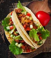 Mexican tacos with meat, vegetables and cheese photo