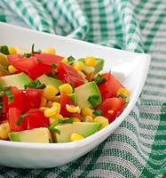 Mixed salad with avocado, tomatoes and sweet corn photo