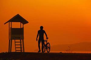 silueta de un ciclista al atardecer en tailandia. foto